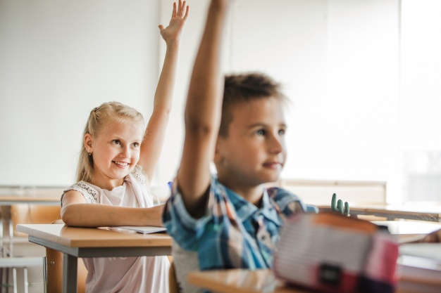 children-sitting-school-desks-raising-hands_23-2147658999